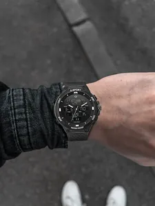 Gros plan de la montre de sport TOMI à double affichage portée au poignet sur fond de rue.