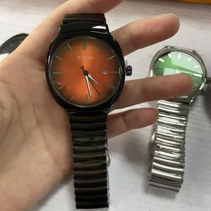 Gros plan d'une montre à quartz TOMI pour homme avec bracelet en métal noir et cadran orange