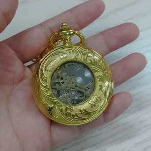 Vue macro détaillée du mécanisme d'une montre de poche mécanique dorée évidée.