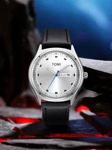 Close-up of TOMI watch with silver sunray dial, dual calendar and black leather strap.