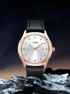 Minimalist TOMI rose gold watch with day-date display and black leather strap on rock