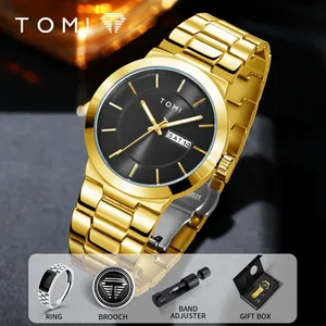 Detailed view of gold men's watch with matching ring, brooch, and gift box accessories