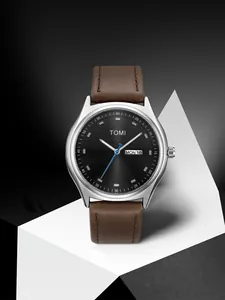 Close-up of the TOMI minimalist watch featuring a brown leather strap and dual date window