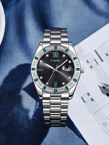 Vue détaillée de la montre en acier TOMI pour hommes avec cadran noir et pierres vertes