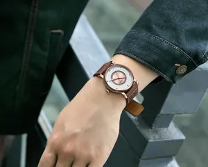 Vista dettagliata dell'orologio minimalista TOMI con cinturino in pelle marrone al polso