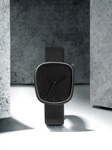 Vue détaillée d'une montre à quartz noire en forme de galet avec une finition mate épurée.