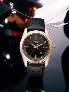 Gros plan sur la montre à quartz TOMI pour homme avec lunette cannelée en or rose et cadran noir.