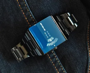 Detail view of men's square quartz watch with blue tinted crystal and black metal strap