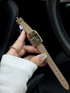 Vue détaillée d'une montre carrée vintage en forme de serrure dorée avec bracelet cuir