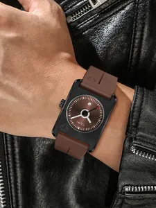 Gros plan d'une montre analogique carrée TOMI avec cadran marron et guichet de date