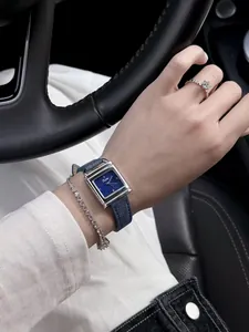 Gros plan élégant d'une montre carrée vintage avec cadran bleu portée au poignet