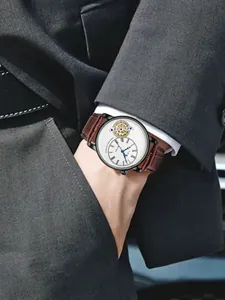 Primo piano dell'orologio al quarzo TOMI da uomo con cinturino in pelle marrone