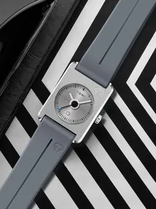 Gros plan de la montre carrée TOMI avec bracelet en silicone gris et boîtier argenté.