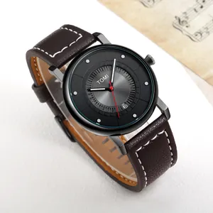 Dettaglio di un orologio minimalista TOMI con cinturino in pelle marrone e data