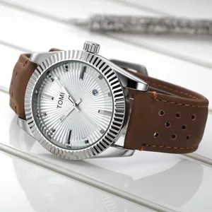 Gros plan sur la montre à quartz TOMI pour homme avec lunette cannelée et bracelet en cuir brun