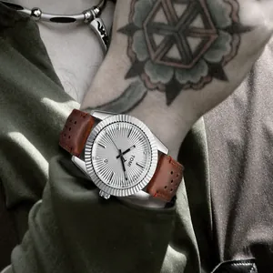 Gros plan d'une montre à quartz TOMI avec lunette cannelée et bracelet en cuir brun