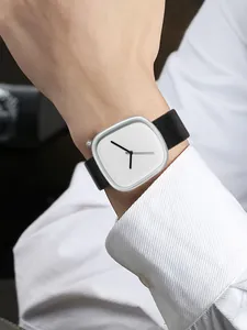 Gros plan d'une montre à quartz minimaliste en forme de galet avec bracelet en cuir