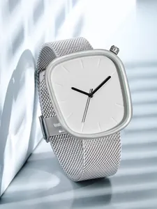 Gros plan sur une montre à quartz minimaliste en forme de galet avec bracelet en maille
