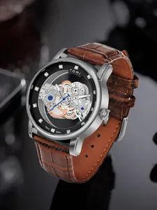 Detailansicht der TOMI Herren Quarzuhr mit Skelettzifferblatt und braunem Lederarmband