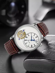 Dettaglio dell'orologio TOMI face gear con quadrante scheletrato e cinturino in pelle.