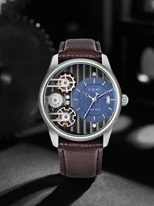 Dettaglio dell'orologio al quarzo TOMI con quadrante blu e design a ingranaggi