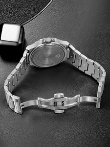 Detailed macro view of the stainless steel back case and deployment buckle of a TOMI watch.