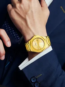 Close-up of TOMI gold stainless steel business watch on a man's wrist in a suit