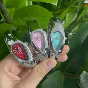 Lot de trois montres bracelets Y2K en forme de goutte avec cadrans rouge, rose et bleu.