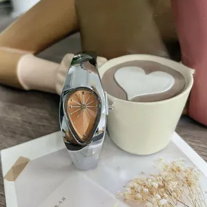 Gros plan d'une montre Y2K argentée en forme de larme avec cadran chic en or rose.