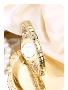 Close-up of the vintage gold-plated metal bracelet watch band on white silk background.