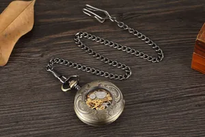 Gros plan d'une montre à gousset mécanique en bronze avec mécanisme à engrenages visible.