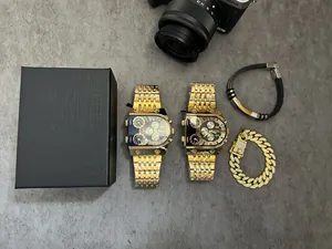 Coffret montre Oulm luxe pour homme, cadran multi-fuseaux horaires or et bracelets.