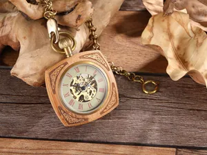 Gros plan d'une montre de poche mécanique carrée en bois de rose avec cadran squelette