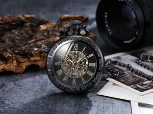Close-up of vintage black skeleton mechanical pocket watch with Roman numerals and metal chain.