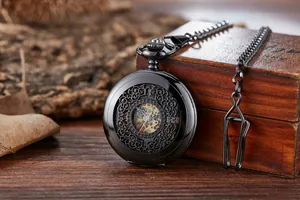 Détail d'une montre à gousset mécanique squelette vintage sur boîte en bois.