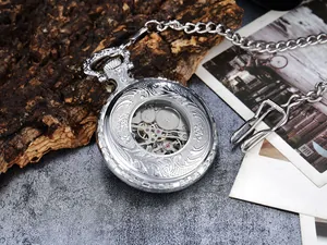 Vintage silver mechanical pocket watch with intricate floral engravings and skeleton detail.