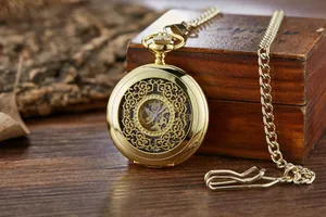 Détail de montre à gousset mécanique automatique dorée squelette sur boîte en bois.