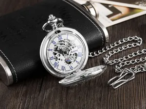 Gros plan d'une montre à gousset mécanique argentée avec chiffres romains bleus