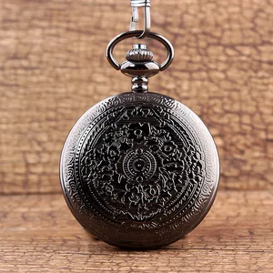 Primer plano de un reloj de bolsillo vintage en metal oscuro con grabado floral en la tapa