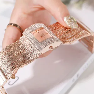 Gros plan détaillé d'une montre à quartz carrée en or rose avec strass et bracelet chaîne
