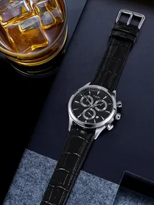 TOMI men's quartz chronograph watch with black leather strap on a luxury lifestyle background.