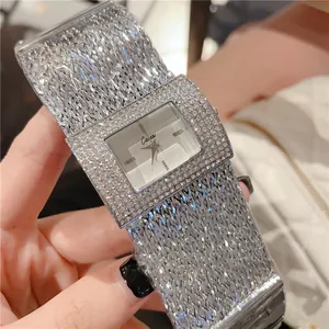 Gros plan d'une montre carrée argentée pour femme avec lunette en strass brillants