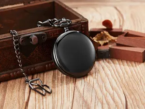 Primer plano de un elegante reloj de bolsillo vintage negro con cadena y caja de madera.