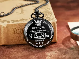 Primer plano detallado de un reloj de bolsillo negro vintage grabado TO MY GRANDPA