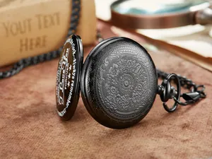 Detalle macro de un reloj de bolsillo negro vintage con grabado floral y texto