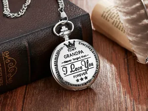 Primer plano de un reloj de bolsillo vintage de plata grabado para el abuelo en mesa