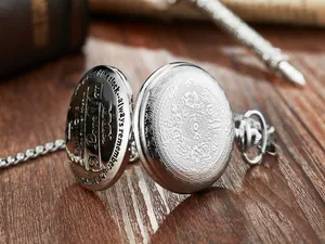 Primer plano de reloj de bolsillo vintage plateado con grabado 'Grandpa' e 'I Love You'.
