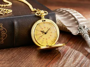Reloj de bolsillo vintage dorado de cuarzo con esfera romana en un fondo rústico