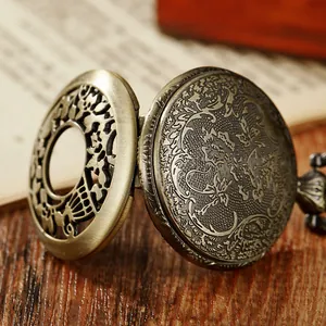 Gros plan détaillé montrant le motif évidé complexe d'une montre à gousset à quartz vintage en bronze.
