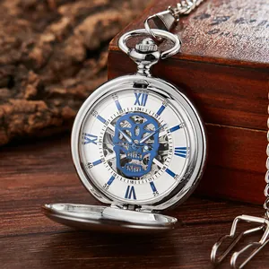 Vue détaillée d'une montre de poche mécanique vintage argentée avec cadran crâne bleu.